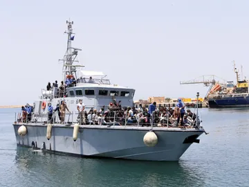 Un barco de la Armada de Libia con inmigrantes a bordo llega a una base Un barco de la Armada de Libia con inmigrantes a bordo llega a una base
