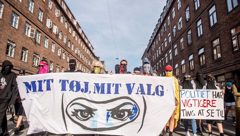 Protestas en Dinamarca con una pancarta en la que se lee "Mi ropa mi decisión"