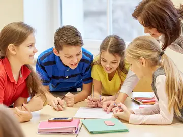 Grupo de niños en clase junto a su profesora Grupo de niños en clase junto a su profesora