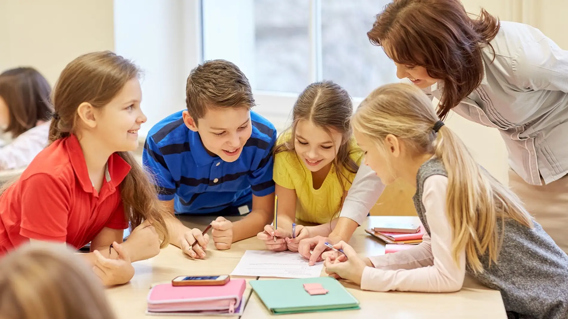 Grupo de niños en clase junto a su profesora