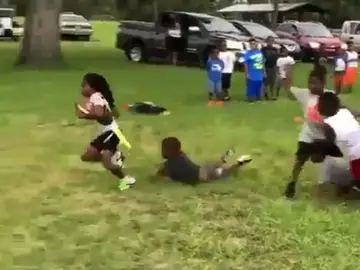 Niño de seis años jugando al fútbol americano Niño de seis años jugando al fútbol americano