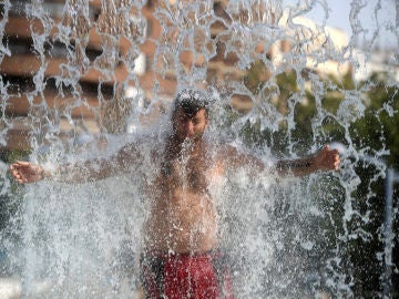 Un hombre se refresca en una fuente de Córdoba durante la ola de calor