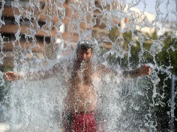 Un hombre se refresca en una fuente de Córdoba durante la ola de calor Un hombre se refresca en una fuente de Córdoba durante la ola de calor