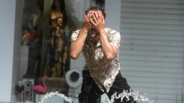 Un hombre intenta refrescarse en una fuente de Córdoba, en una jornada marcada por la ola de calor que afecta a toda la Península