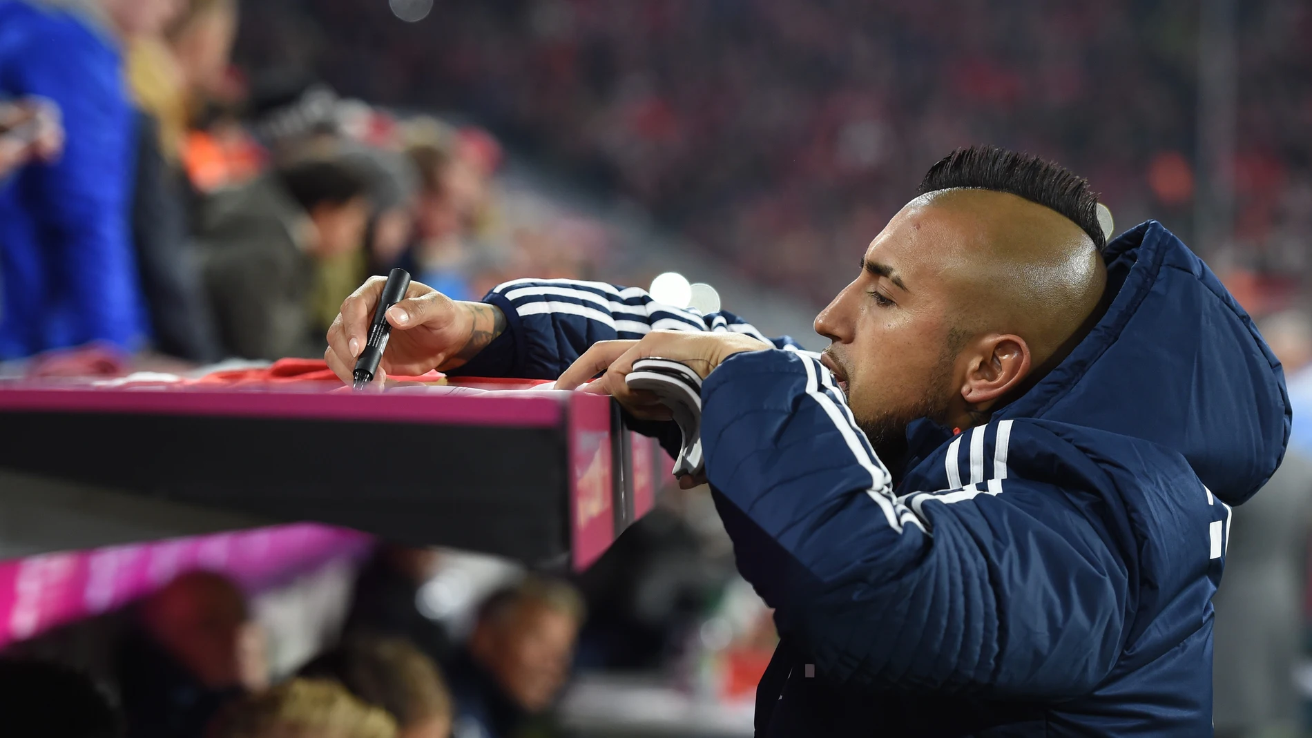 Arturo Vidal firma la camiseta de un aficionado en un partido del Bayern Arturo Vidal firma la camiseta de un aficionado en un partido del Bayern