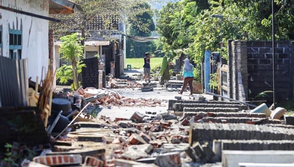 Varios vecinos caminan entre los escombros tras el terremoto de Lombok