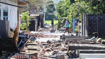 Varios vecinos caminan entre los escombros tras el terremoto de Lombok
