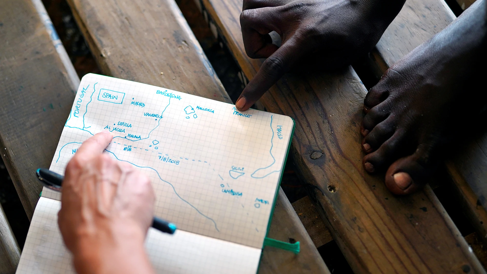 Un miembro del Open Arms muestra a un tripulante un mapa de la ubicación de Algeciras Un miembro del Open Arms muestra a un tripulante un mapa de la ubicación de Algeciras