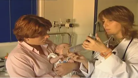 Médico atendiendo a bebé con inhalador Médico atendiendo a bebé con inhalador