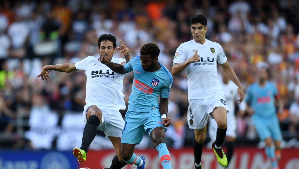 Lemar conduce el balón ante la presión de Parejo y Carlos Soler