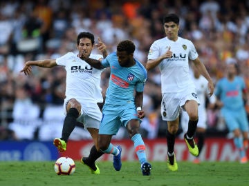 Lemar conduce el balón ante la presión de Parejo y Carlos Soler