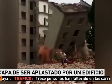 Un hombre se salva de un edificio que se derrumba delante de él Un hombre se salva de un edificio que se derrumba delante de él