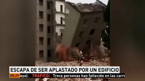 Un hombre se salva de un edificio que se derrumba delante de él Un hombre se salva de un edificio que se derrumba delante de él