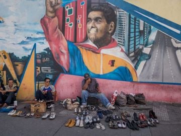 Vendedores ambulantes ofrecen sus productos frente a locales comerciales cerrados en Caracas