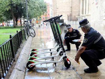 Unos agentes de la Policía Local trabajan en la retirada de los patinetes Unos agentes de la Policía Local trabajan en la retirada de los patinetes