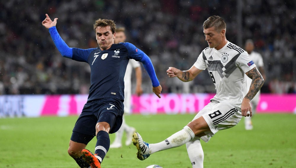 Kroos pasa el balón ante la defensa de Griezmann