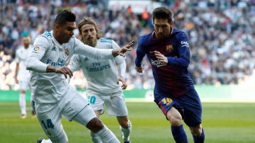 Casemiro intenta arrebatar el balón a Messi