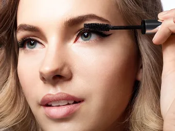 Mujer aplicándose rimmel Mujer aplicándose rimmel