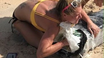 Una mujer abrazando un saco de marihuana tras el paso de Florence