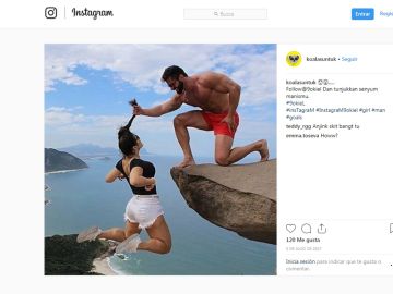 Una chica colgando sobre un precipicio, agarrada por un chico Una chica colgando sobre un precipicio, agarrada por un chico