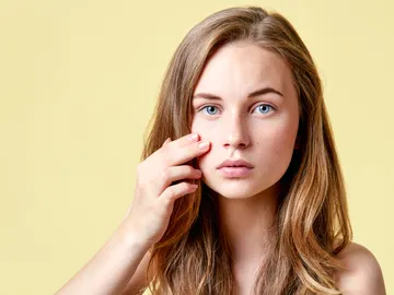 Una chica se mira la piel Una chica se mira la piel