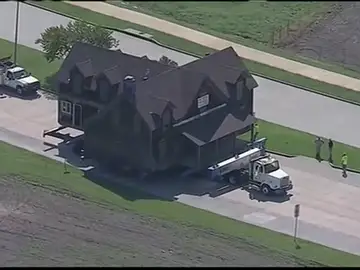 Una familia compra una casa y la traslada a su terreno con un camión Una familia compra una casa y la traslada a su terreno con un camión