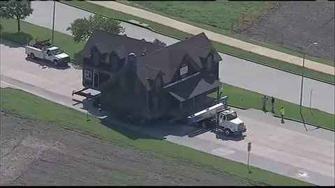 Una familia compra una casa y la traslada a su terreno con un camión Una familia compra una casa y la traslada a su terreno con un camión