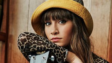 Aitana posando junto a una guitarra