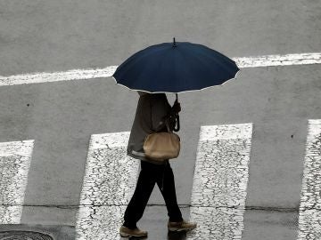 Una mujer se protege con un paraguas ante la lluvia