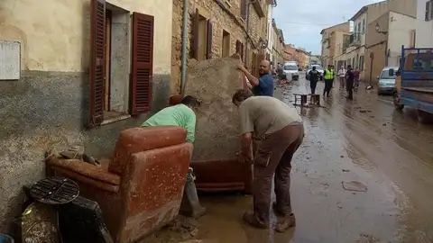 Vecinos de Sant Llorenç limpian el lodo de sus muebles Vecinos de Sant Llorenç limpian el lodo de sus muebles