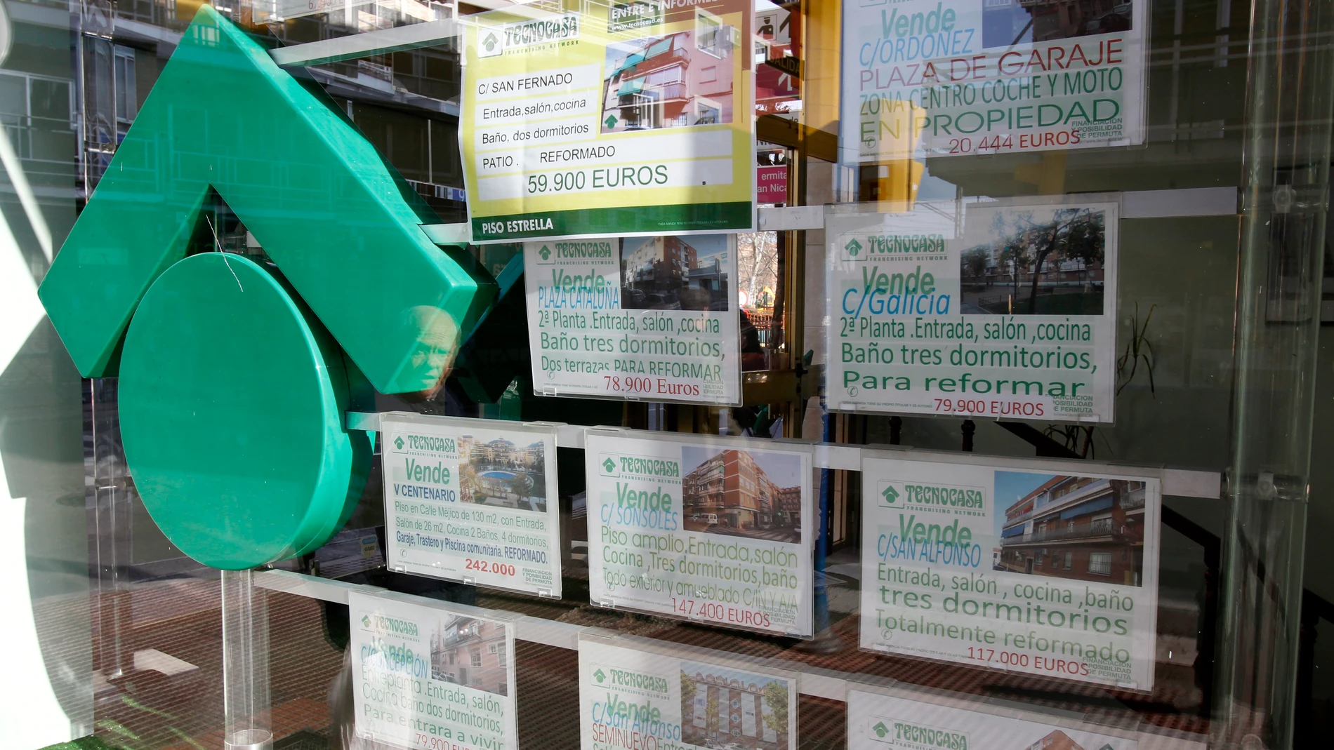 Numerosos carteles de venta de pisos ocupan el escaparate de una entidad inmobiliaria Numerosos carteles de venta de pisos ocupan el escaparate de una entidad inmobiliaria