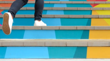 Una mujer camina escaleras arriba Una mujer camina escaleras arriba