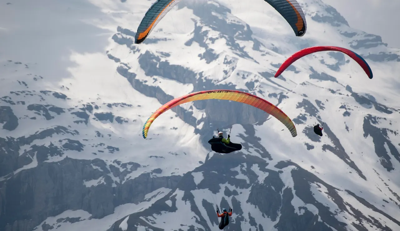 Parapentistas vuelan sobre una montaña en una imagen de archivo