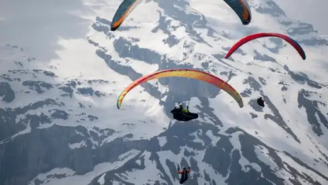 Parapentistas vuelan sobre una montaña en una imagen de archivo Parapentistas vuelan sobre una montaña en una imagen de archivo