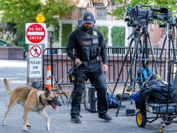 Un miembro del Servicio Secreto de los Estados Unidos y un perro policía Un miembro del Servicio Secreto de los Estados Unidos y un perro policía