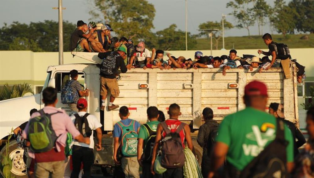Migrantes hondureños suben a un camión durante el inicio de otro día de travesía hacia EEUU