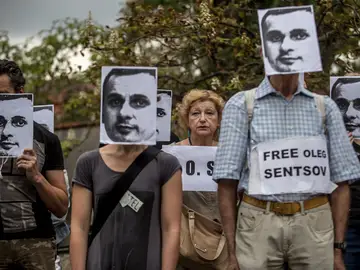 Varias personas sostienen pancartas y máscaras del cineasta ucraniano encarcelado en Rusia, Oleg Sentsov Varias personas sostienen pancartas y máscaras del cineasta ucraniano encarcelado en Rusia, Oleg Sentsov