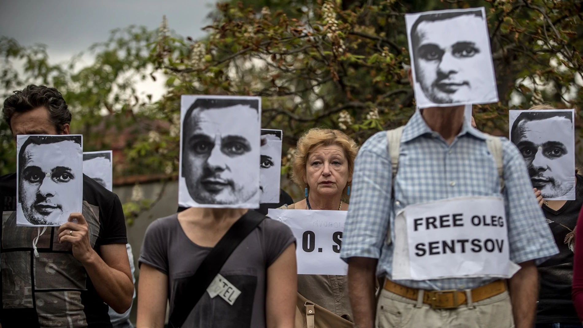 Varias personas sostienen pancartas y máscaras del cineasta ucraniano encarcelado en Rusia, Oleg Sentsov Varias personas sostienen pancartas y máscaras del cineasta ucraniano encarcelado en Rusia, Oleg Sentsov