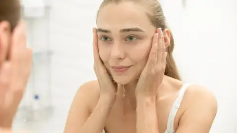 Mujer lavándose la cara Mujer lavándose la cara