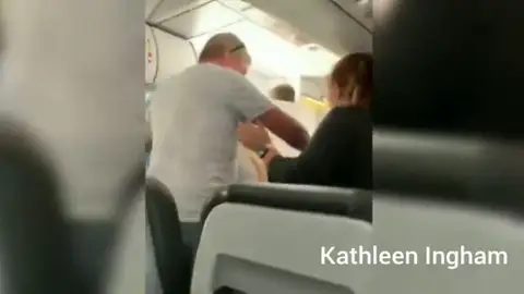 Un pasajero abre una de las puertas del avión cuando se preparaban para el despegue Un pasajero abre una de las puertas del avión cuando se preparaban para el despegue