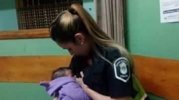Una policía amamantando a un niño