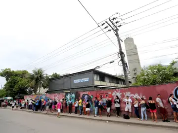 Decenas de brasileños esperan a las puertas de un colegio electoral para votar Decenas de brasileños esperan a las puertas de un colegio electoral para votar