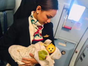 Una azafata de vuelo amamantando a un bebé