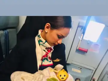 Una azafata de vuelo amamantando a un bebé Una azafata de vuelo amamantando a un bebé