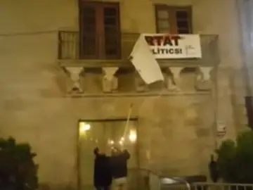Dos personas descuelgan la pancarta por los políticos presos del balcón del Ayuntamiento de Cervera Dos personas descuelgan la pancarta por los políticos presos del balcón del Ayuntamiento de Cervera