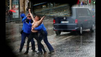 Una activista de Femen, detenida en topless antes de alcanzar la caravana de Trump en la celebración del fin de la Primera Guerra Mundial