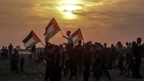 Varios palestinos ondean sus banderas durante enfrentamientos con soldados israelíes en la Franja de Gaza Varios palestinos ondean sus banderas durante enfrentamientos con soldados israelíes en la Franja de Gaza