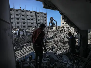 Un par de palestinos caminan entre los escombros en Gaza Un par de palestinos caminan entre los escombros en Gaza