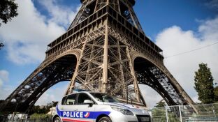 Un coche de la Polic&iacute;a francesa frente a la Torre Eiffel de Par&iacute;s