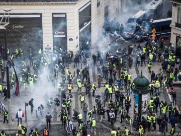 Chalecos amarillos se enfrentan a las fuerzas policiales durante una manifestación cerca de los Campos Elíseos en París